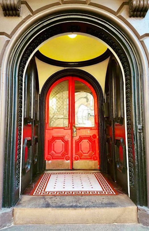 Red door, yellow ceiling and black rimmed arch entrance